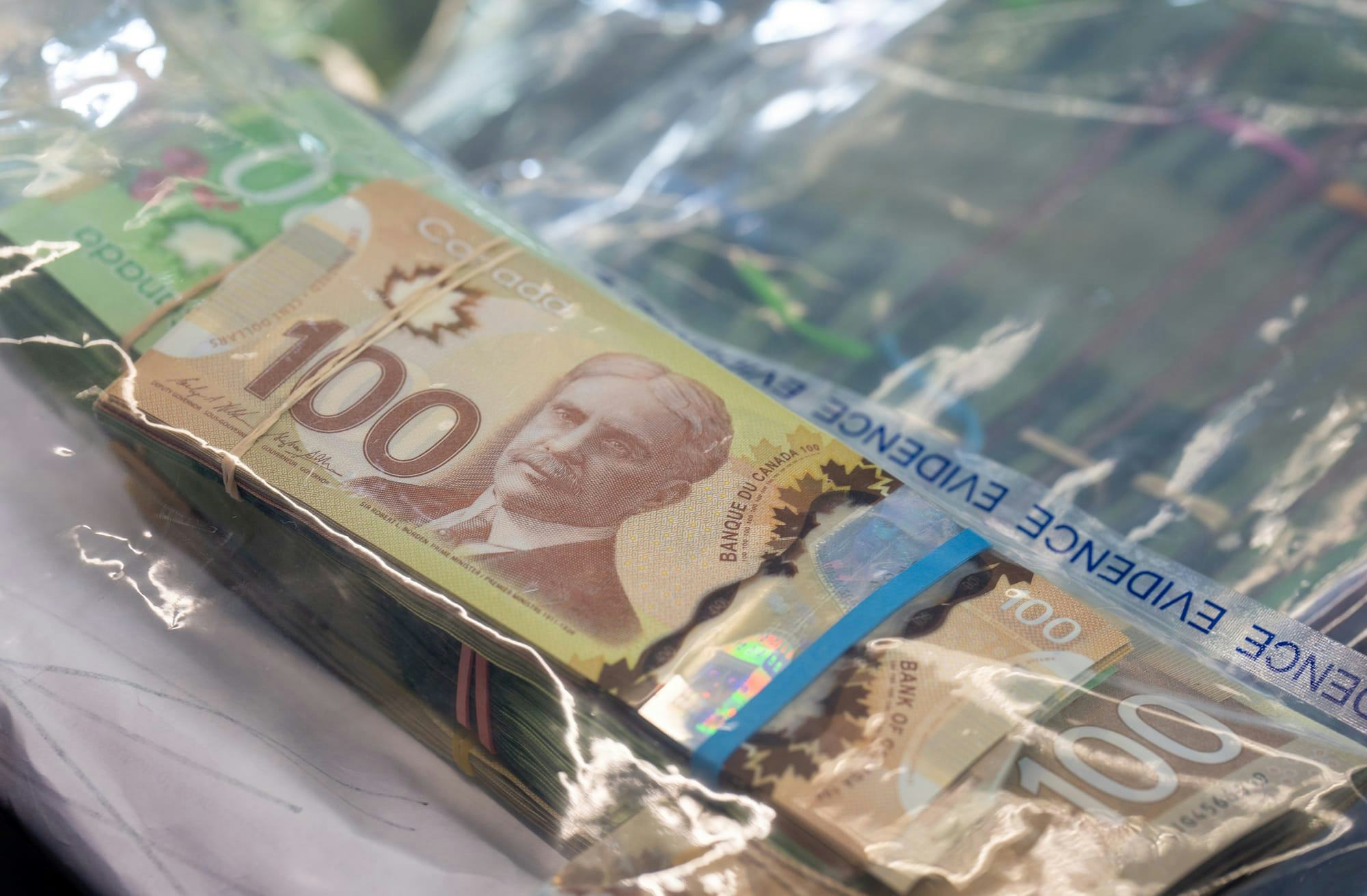 Banded Canadian currency inside in a clear plastic bag labelled "evidence." 
