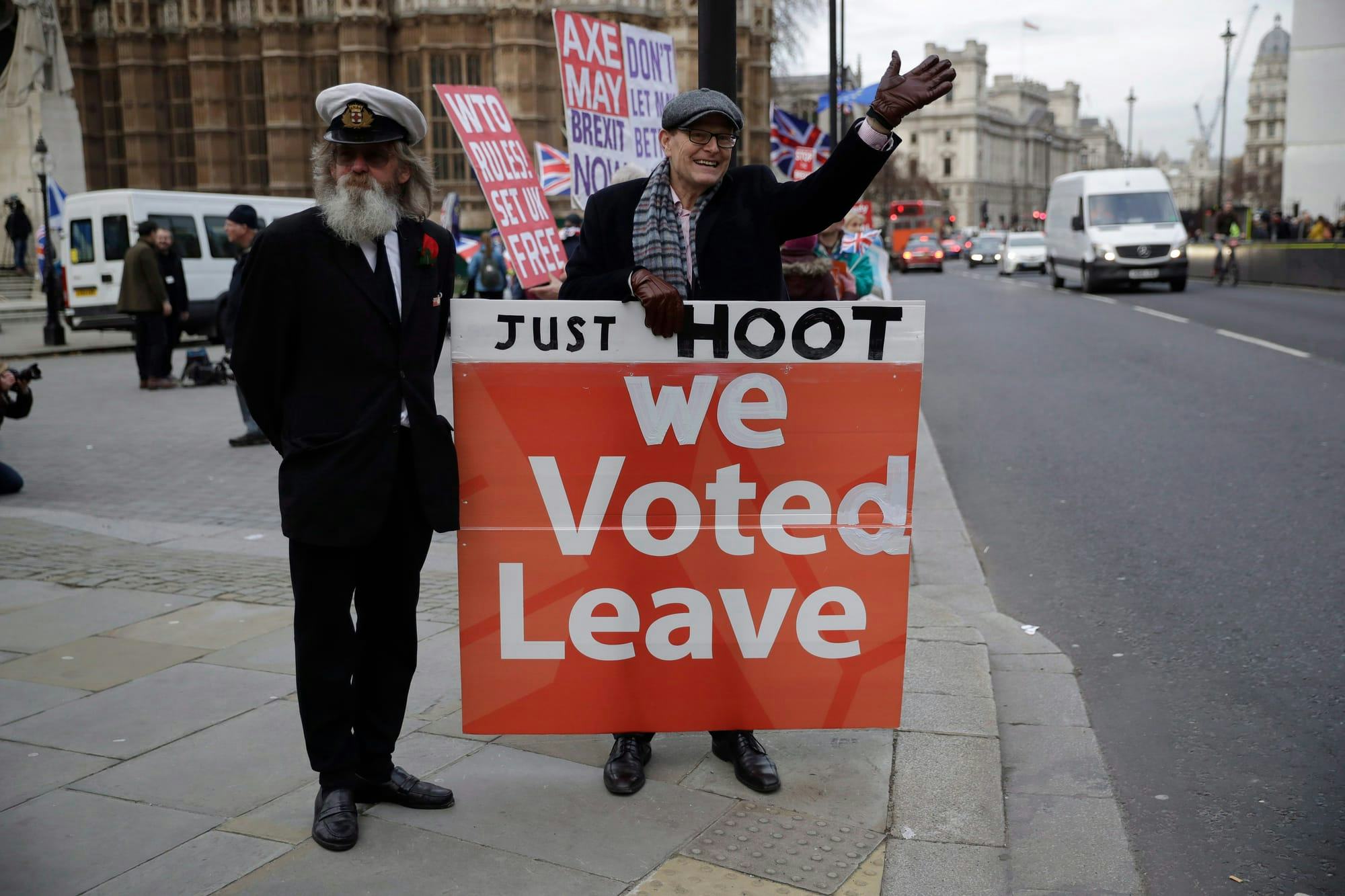 A Brexit supporter holds a sign saying "JUST HOOT: we Voted Leave" at a protest in London, U.K.